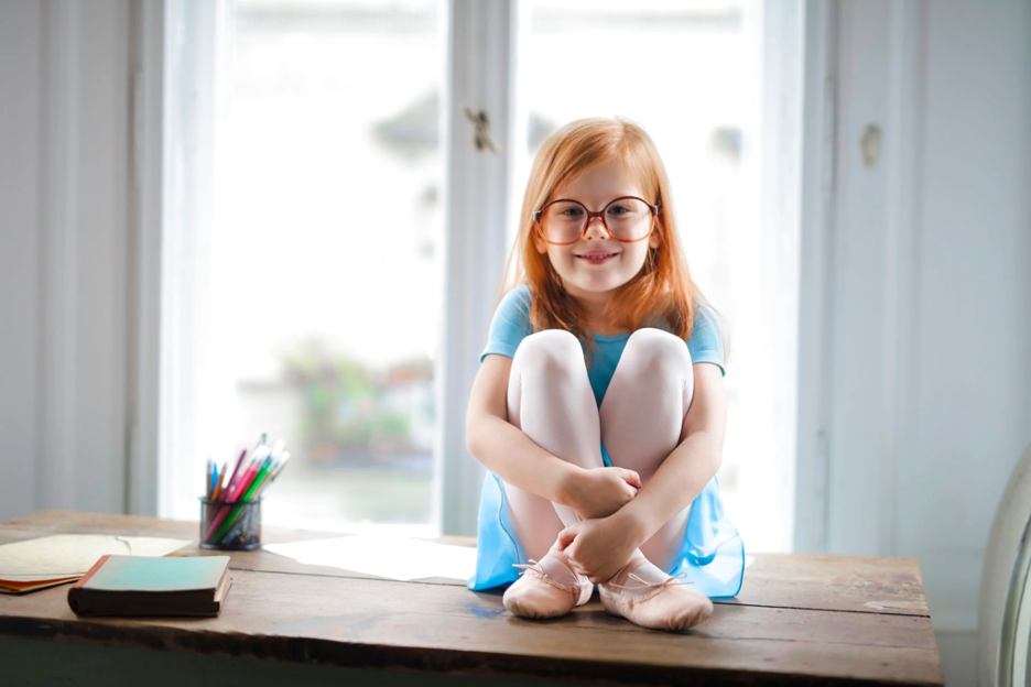 girl with crossed legs sitting on table
