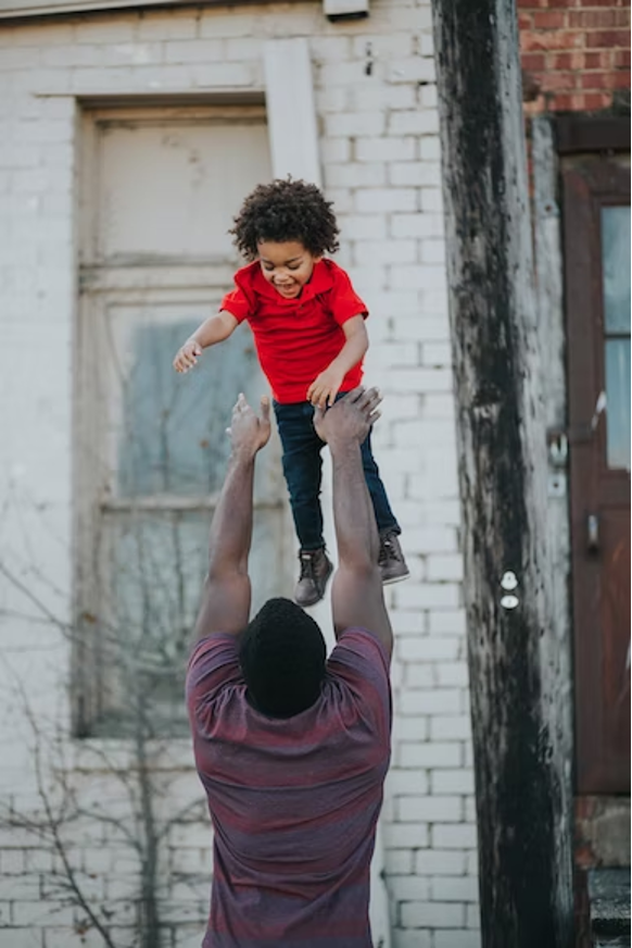 child being playfully thrown in the air and enjoying it